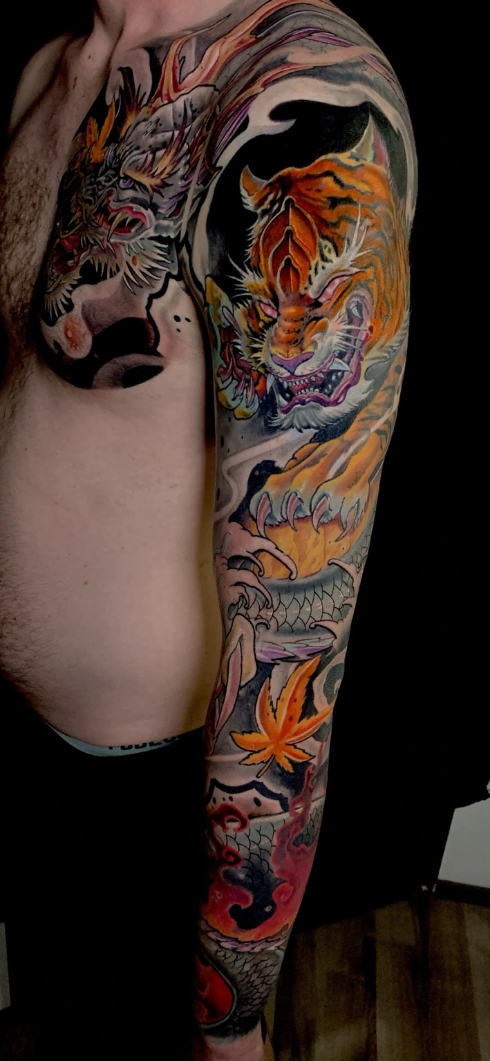 Japanisch inspiriertes Arm-Tattoo mit Tiger und Drachen in Farbe
